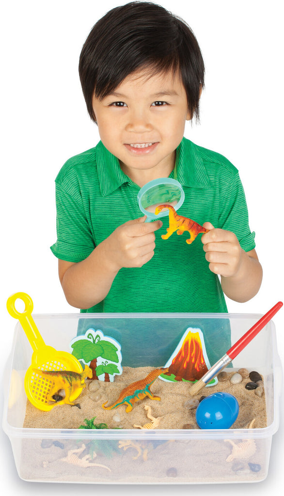 Creativity for Kids Sensory Bin Dinosaur Dig with kinetic sand, dinosaur fossils, and excavation tools