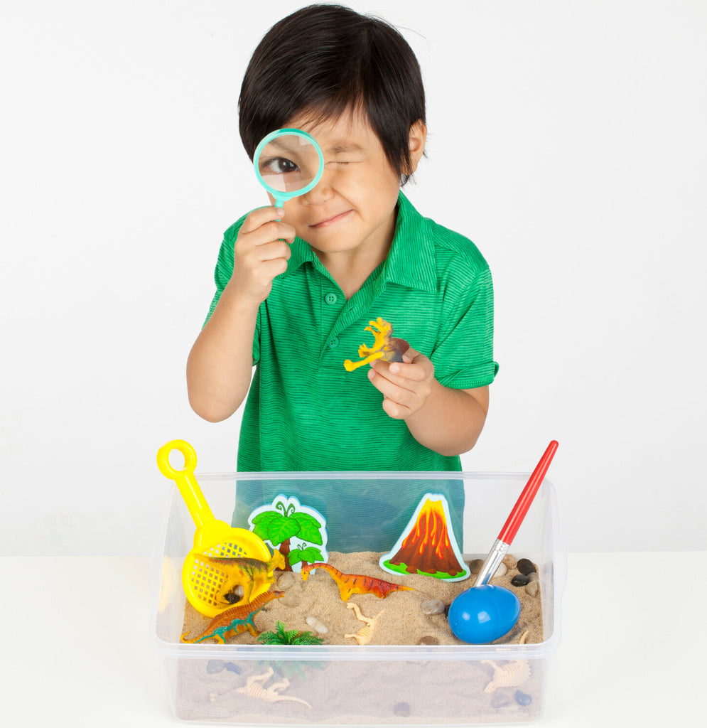 Creativity for Kids Sensory Bin Dinosaur Dig with kinetic sand, dinosaur fossils, and excavation tools