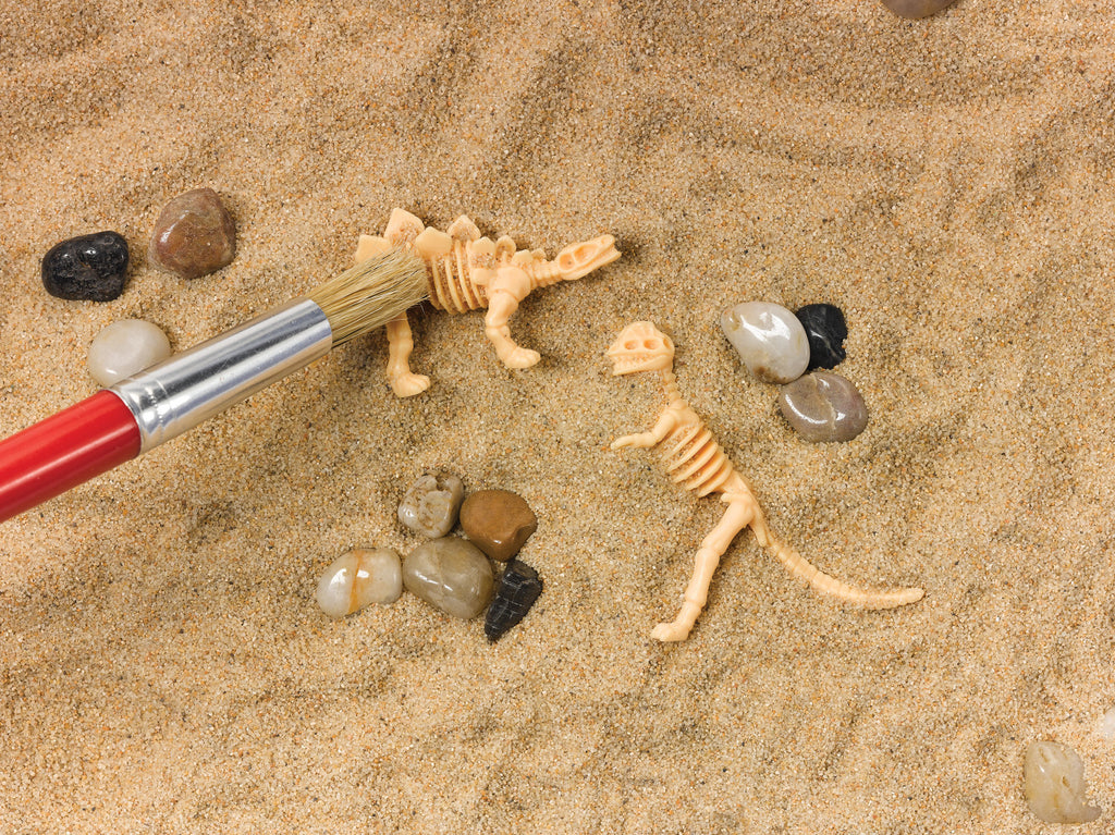 Creativity for Kids Sensory Bin Dinosaur Dig with kinetic sand, dinosaur fossils, and excavation tools