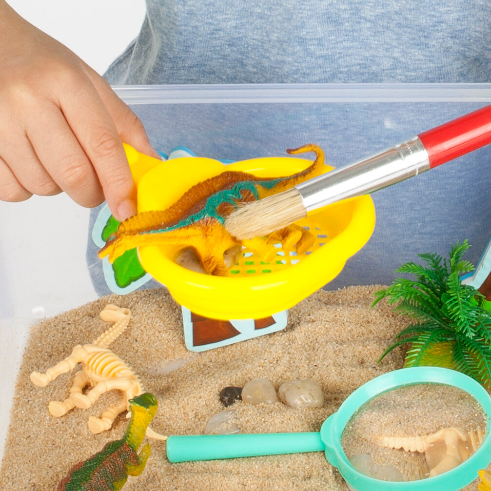 Creativity for Kids Sensory Bin Dinosaur Dig with kinetic sand, dinosaur fossils, and excavation tools