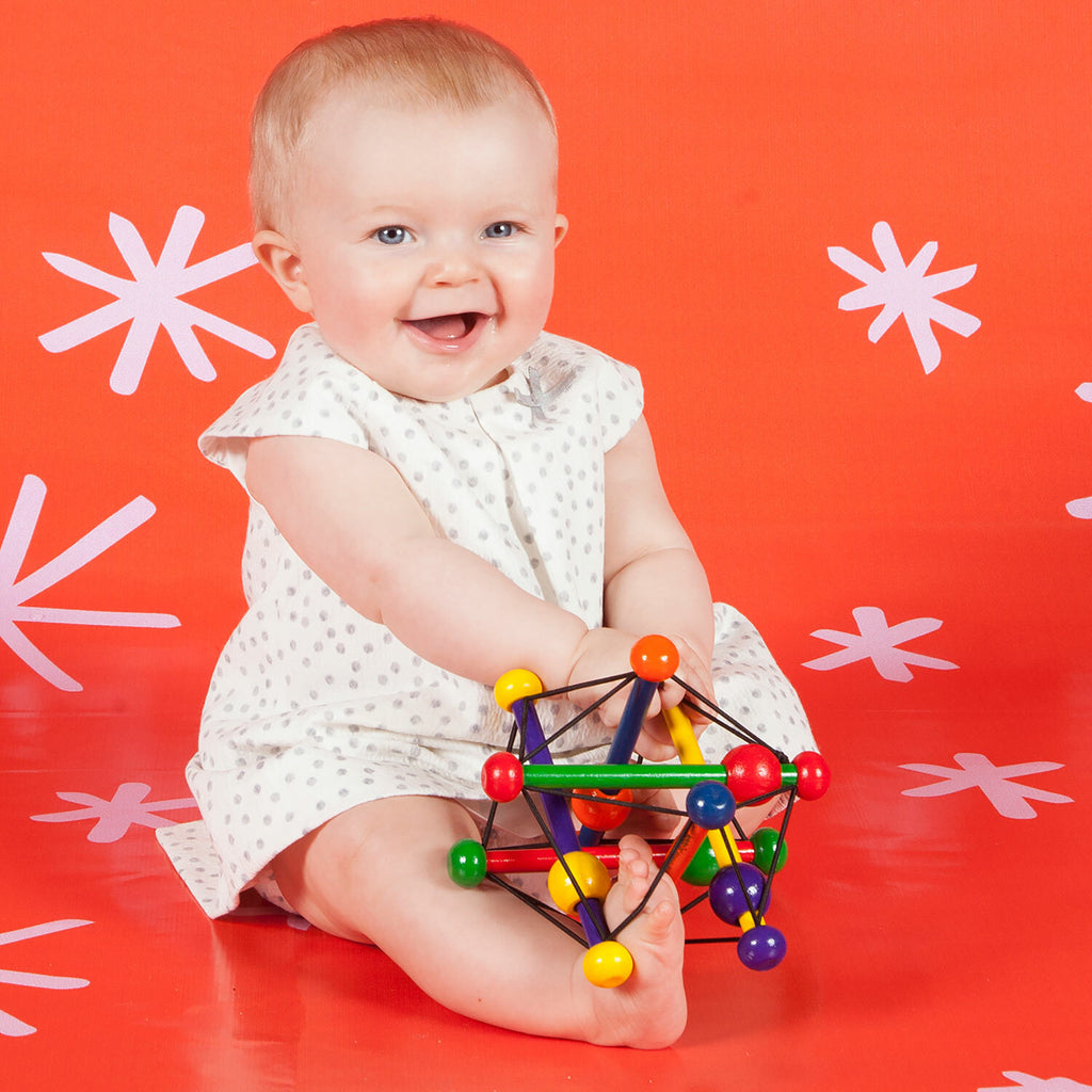 Manhattan Toy Skwish Classic wooden rattle and teether that compresses and returns to original shape with sliding beads