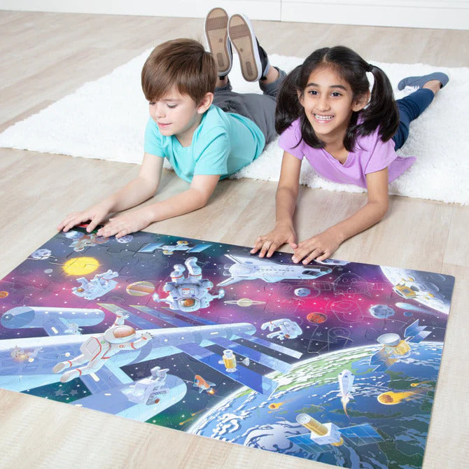 Outer Space Glow in the Dark Floor Puzzle showing colorful space scene with planets, astronauts, and spaceships that glows in the dark