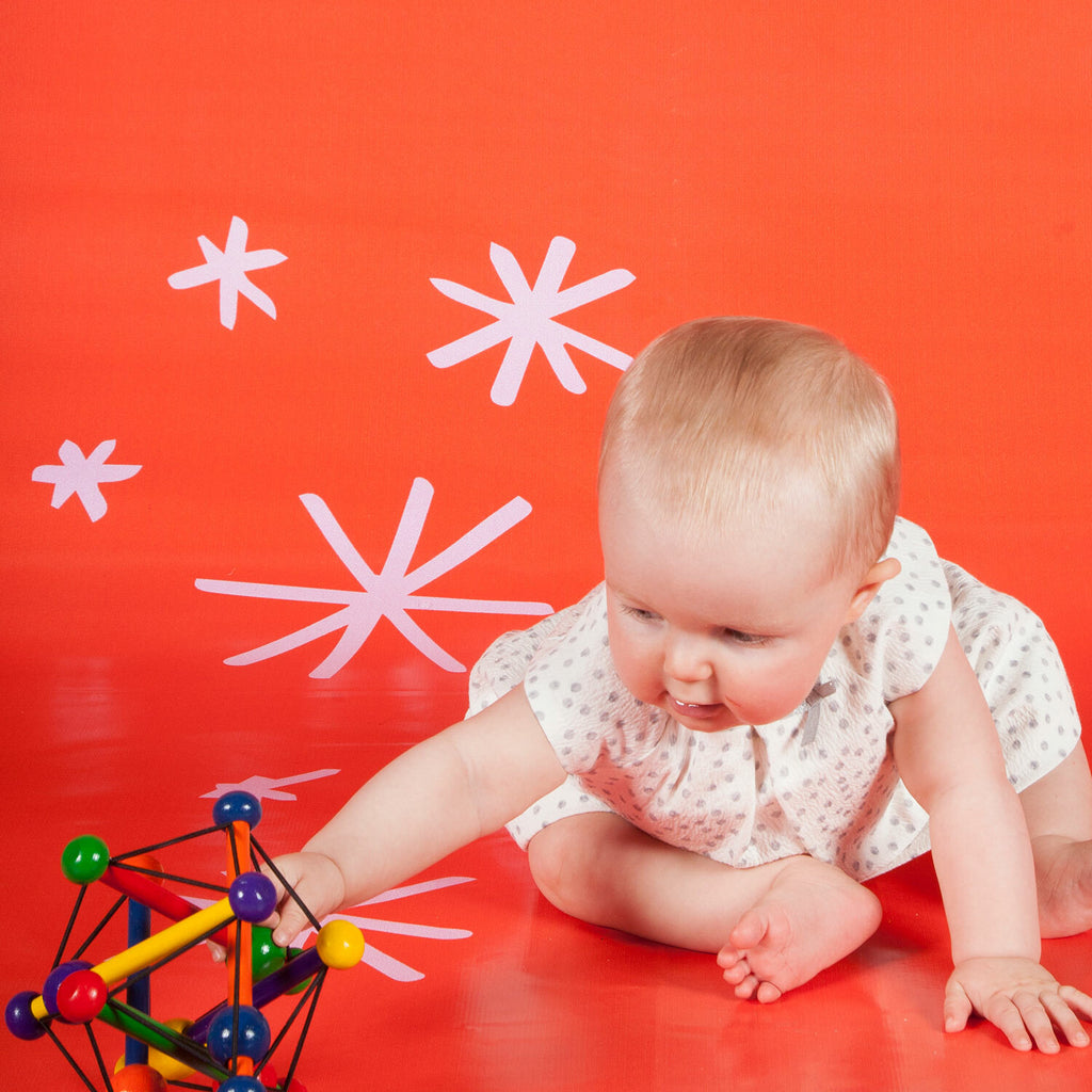 Manhattan Toy Skwish Classic wooden rattle and teether that compresses and returns to original shape with sliding beads