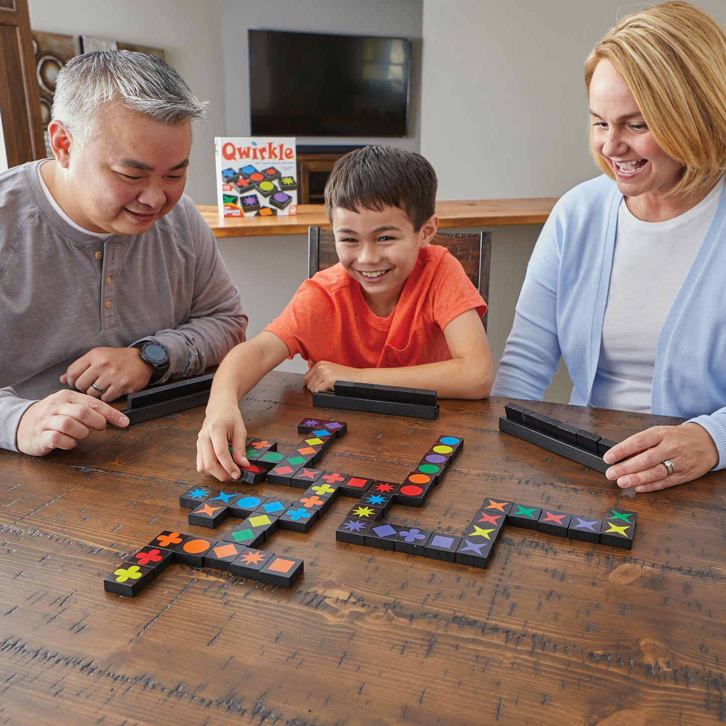 Qwirkle strategy tile game with colorful shapes and tiles for family game night, combining colors and patterns